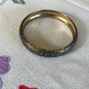Silver toned bangle with floral engravings